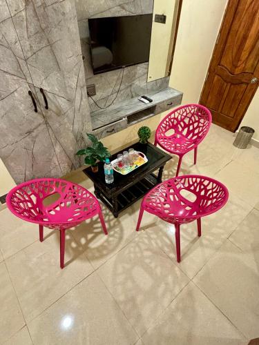 three pink chairs and a table in a bathroom at Royal Dreams Beach View in Puducherry