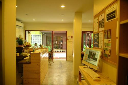 a restaurant with a counter with a computer on a desk at PanPan Hostel in Bangkok
