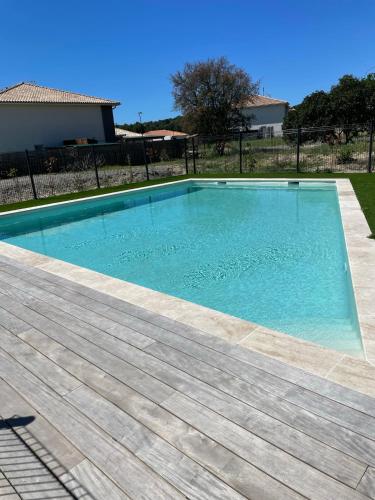 une piscine avec de l'eau bleue dans une cour dans l'établissement Maison fonctionnelle et bien située, à Mimizan
