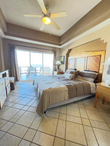 a bedroom with a large bed with a ceiling fan at Girasol Maximilian en la Playa Sandy Beach in Puerto Peñasco