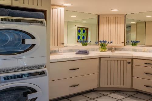 a laundry room with a washer and dryer at Ocean Breeze Bungalow by Paradise Retreats in Summerland
