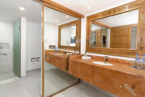 a bathroom with two sinks and two mirrors at Beachscape Kin Ha Villas & Suites in Cancún