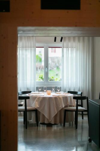 a table with wine glasses on it with a window at Locanda San Lorenzo in Puos dʼAlpago
