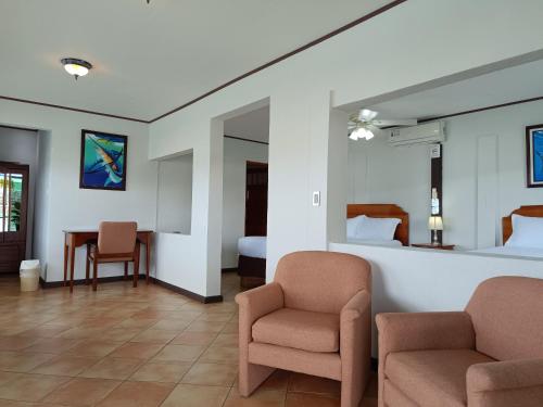 a hotel room with two chairs and a bed at Banana Bay Marina in Golfito