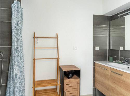 une salle de bain avec un lavabo et un rideau de douche dans l'établissement Maison fonctionnelle et bien située, à Mimizan