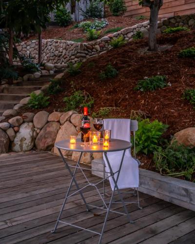 a table with a bottle of wine and glasses on it at Ocean View Loft by Paradise Retreats in Summerland