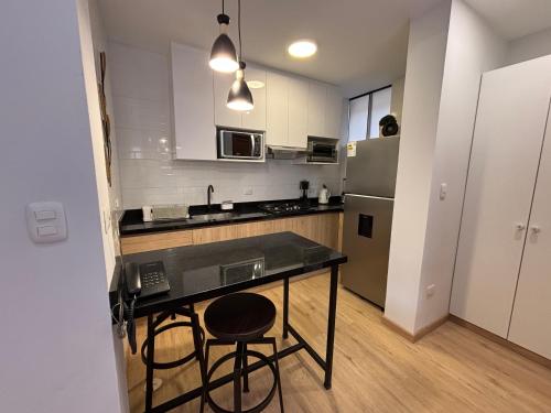 a kitchen with a black counter and a refrigerator at Sori Apartments in Lima