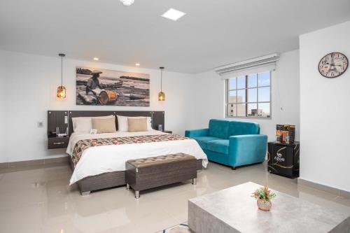 a bedroom with a large bed and a blue couch at Azor Hotel Cali Versalles in Cali
