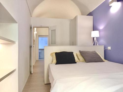 een slaapkamer met een groot wit bed met paarse muren bij Sole Mio in Sanremo