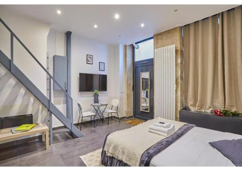 une chambre avec un grand lit et un escalier dans l'établissement Studio Center of Paris Montmartre by Studio prestige, à Paris