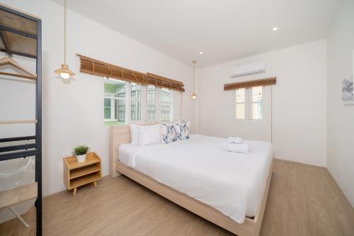 a bedroom with a large white bed and a window at Happiness Pool villa Phuket Patong 154 in Patong Beach