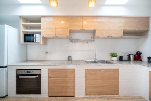 a kitchen with wooden cabinets and a sink at Happiness Pool villa Phuket Patong 154 in Patong Beach