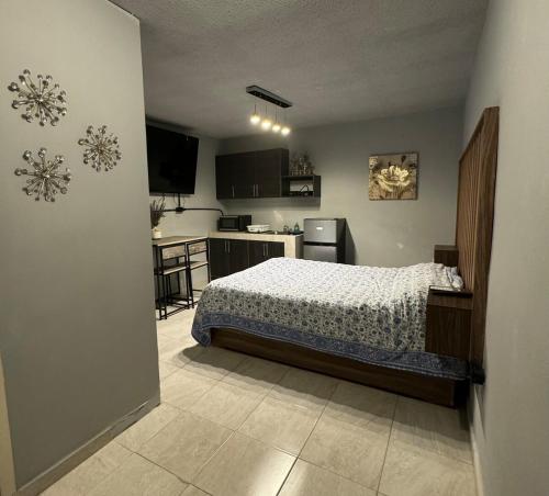 a small bedroom with a bed and a kitchen at Estancias Nava #3 in San Antonio