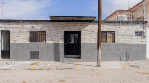 a brick building with a black door on a street at Estancias Nava #3 in San Antonio
