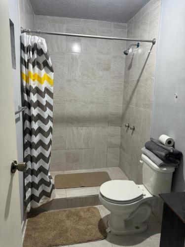 a bathroom with a shower with a toilet and a shower curtain at Estancias Nava #3 in San Antonio