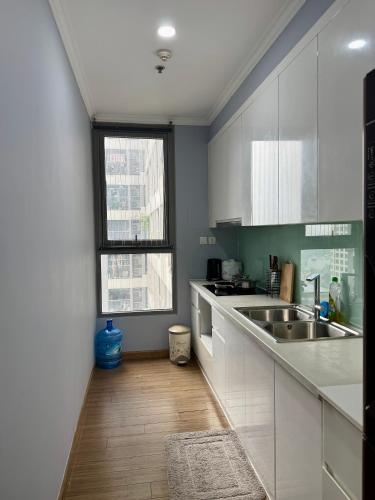 a kitchen with white cabinets and a sink at Vinhomes Times City - QMP in Hanoi