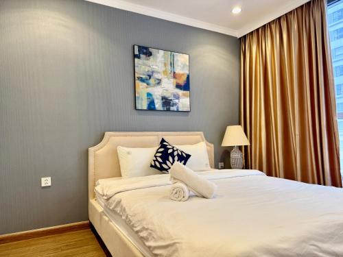 a bedroom with a white bed with a window at Vinhomes Times City - QMP in Hanoi