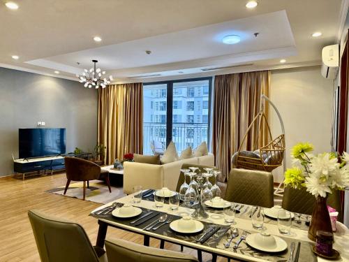 a living room with a dining table and a couch at Vinhomes Times City - QMP in Hanoi