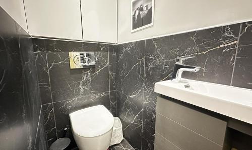 une salle de bain avec des toilettes blanches et un lavabo dans l'établissement Chic 1 room apartment Near Louvre & Palais Garnier, à Paris