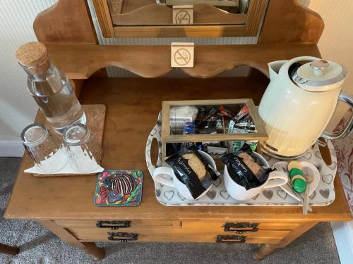 a wooden table with a tea set on top of it at Y Llew Coch in Conwy