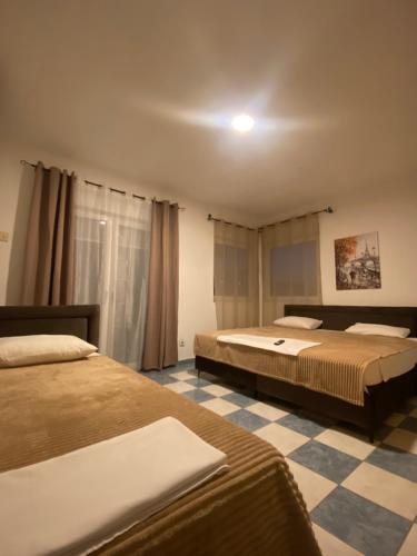 una camera con due letti e un pavimento a scacchi di Starlight Apartments a Ulcinj