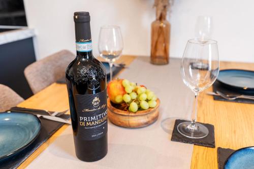 a bottle of wine sitting on a table with wine glasses at Archies Cozy Retreat A Stylish Derby Hideaway in Derby