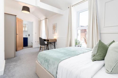 a white bedroom with a bed and a desk at Archies Cozy Retreat A Stylish Derby Hideaway in Derby