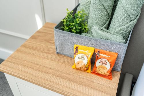 a counter with two bags of snacks on a table at Archies Cozy Retreat A Stylish Derby Hideaway in Derby