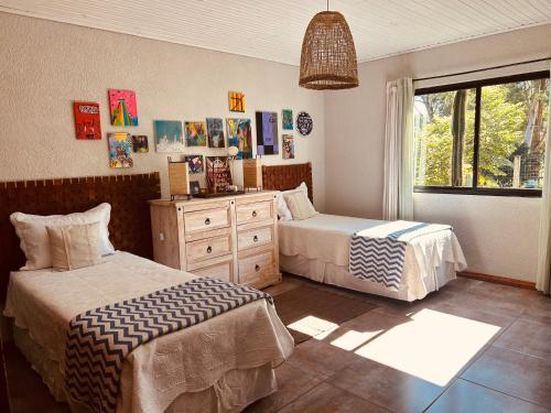 a bedroom with two beds and a dresser and a window at Casa rural in Rivera