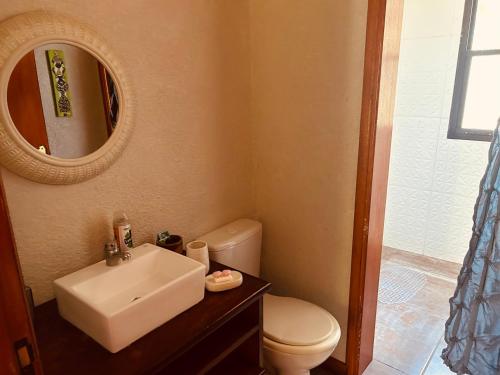 a bathroom with a sink and a toilet and a mirror at Casa rural in Rivera