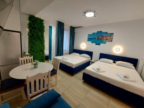 a hotel room with two beds and a table at Mamaia Nord Resort Premium in Mamaia Sat/Năvodari