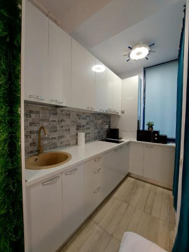 a white kitchen with a sink and a window at Mamaia Nord Resort Premium in Mamaia Sat/Năvodari