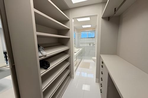 a walk in closet with white counters and shelves at Ed. Premium in Curro Velho