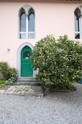 a green door on a white building with a tree at Il Casale Di Villa Rossi in Lucca