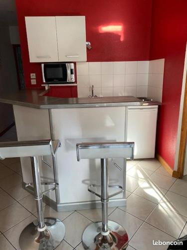 une cuisine avec un comptoir et deux tabourets de bar dans l'établissement sob appart, à Paris