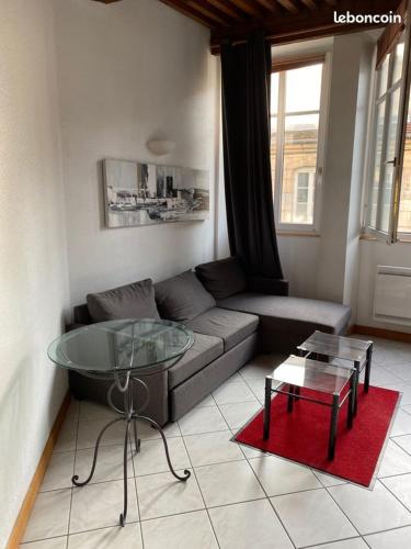 un salon avec un canapé et une table en verre dans l'établissement sob appart, à Paris