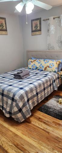 a bedroom with a bed with a plaid blanket at Happiness queen room 3 in Newark