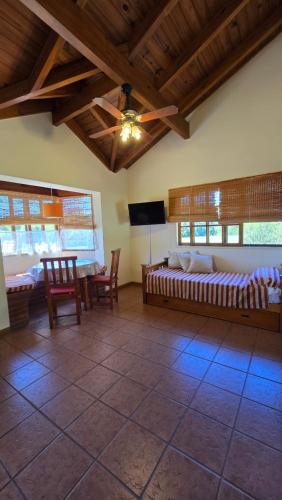 a room with a bed and a table and chairs at Rincón de los Sueños in Villa General Belgrano