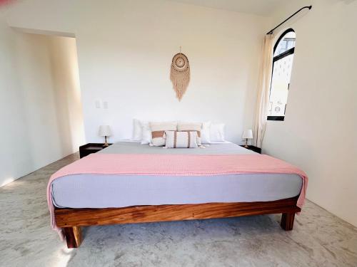 a bedroom with a large bed with a pink blanket at Mountain View, King Bed, Saltwater Pool, Kitchen, Fast WiFi, Air Conditioning - Montana at Casa Calavera in San Francisco