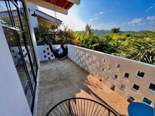 a balcony with a hammock on a house at Mountain View, King Bed, Saltwater Pool, Kitchen, Fast WiFi, Air Conditioning - Montana at Casa Calavera in San Francisco