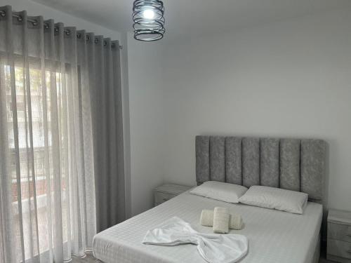 a bedroom with a bed with two towels on it at Mehmeti Apartment in Sarandë