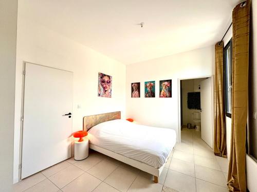 une chambre avec un lit blanc dans une pièce dans l'établissement L'Artelier,T2 centre Nîmes, lit 160, CLIM, à Nîmes