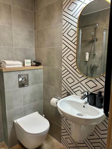 a bathroom with a sink and a toilet and a mirror at Villa Nautica in Łeba