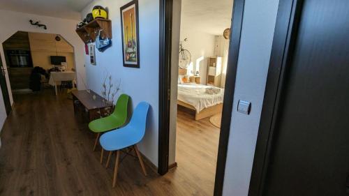 a room with two green chairs and a bedroom at Dynamic Bike Home in Curtea de Argeş