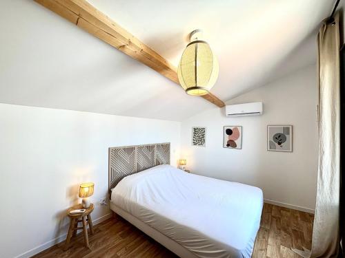 une chambre avec un lit et un ventilateur de plafond dans l'établissement Le Luma, Spacieux T3 – 6 pers, centre Nîmes, CLIM, à Nîmes