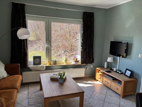 a living room with a large window and a table at Das Eulennest in Sankt Andreasberg