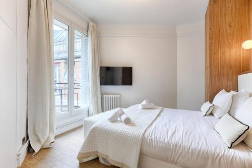 une chambre blanche avec un lit et une fenêtre dans l'établissement Appartement de Luxe avec terrasse sur les Champs Elysées, à Paris