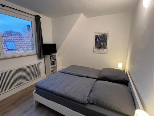a small bedroom with a bed and a window at Etzhorner Tied 3 in Oldenburg