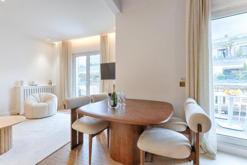 une salle à manger avec une table et des chaises en bois dans l'établissement Appartement de Luxe avec terrasse sur les Champs Elysées, à Paris