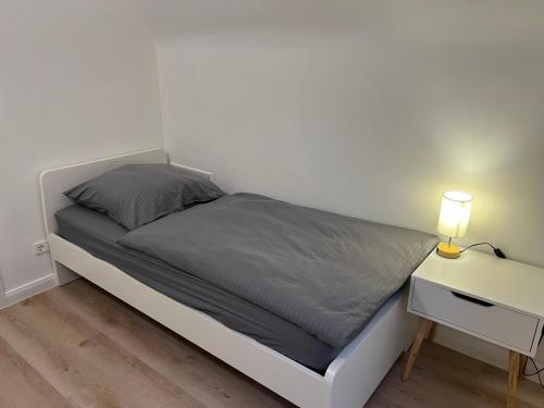 a bedroom with a bed and a nightstand with a lamp at Etzhorner Tied 3 in Oldenburg